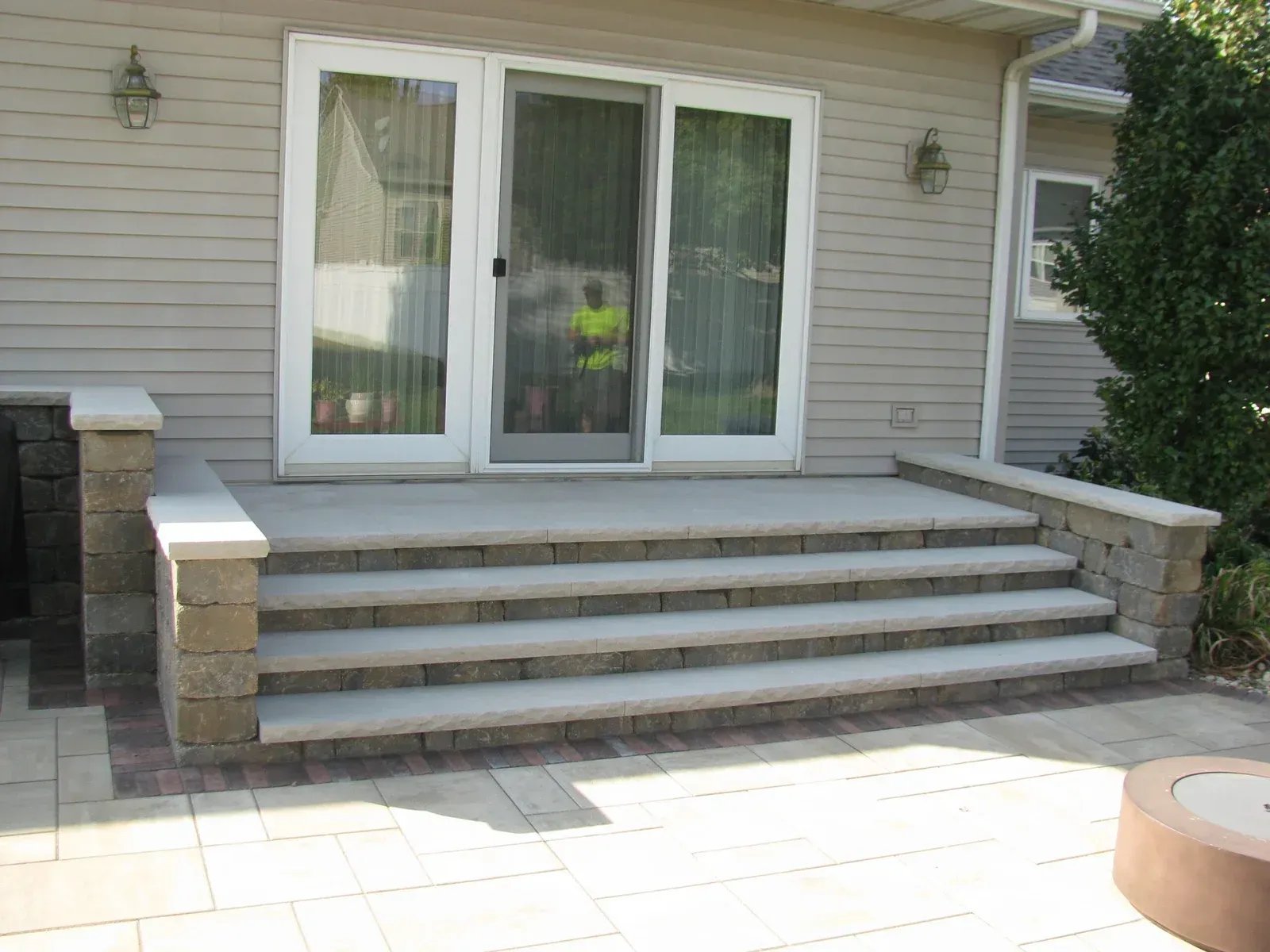 A patio with stairs leading up to a sliding glass door — Waterloo, IA — Matthias Landscaping Co