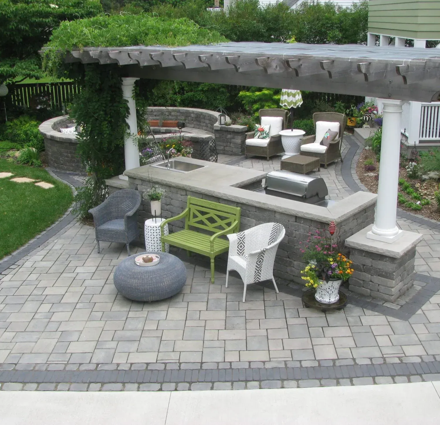 A patio with chairs and a table under a pergola — Waterloo, IA — Matthias Landscaping Co