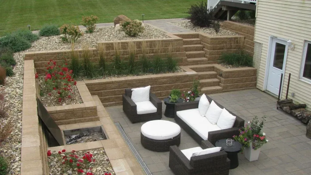 A patio with a couch and chairs in front of a house — Waterloo, IA — Matthias Landscaping Co