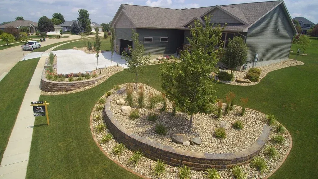 An aerial view of a house with a circular lawn in front of it — Waterloo, IA — Matthias Landscaping Co
