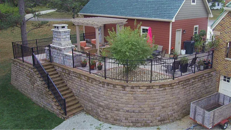 An aerial view of a house with a patio and stairs leading up to it — Waterloo, IA — Matthias Landscaping Co