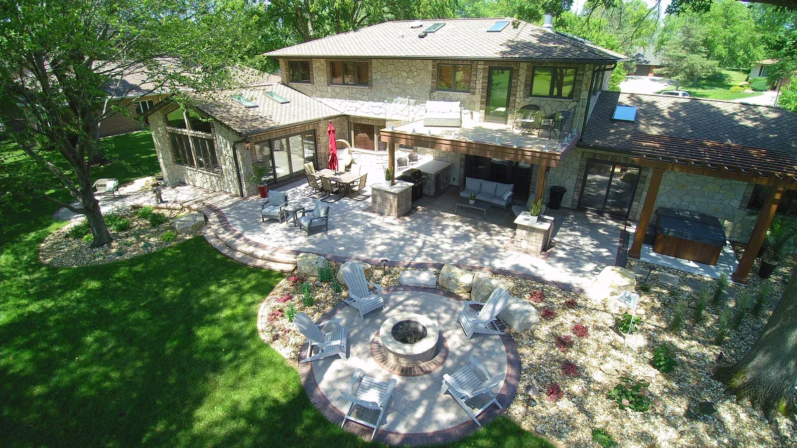 An aerial view of a large house with a fire pit in the backyard — Waterloo, IA — Matthias Landscaping Co