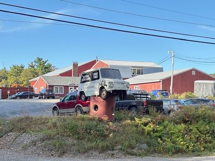 Cars parked in a row on asphalt in a parking lot on a sunny day.