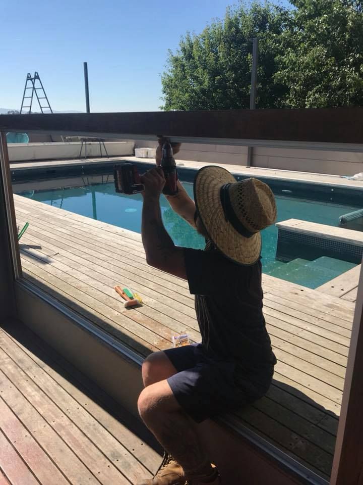 A Man is Installing a glass pool window — Twin Cities Glass In Albury, NSW