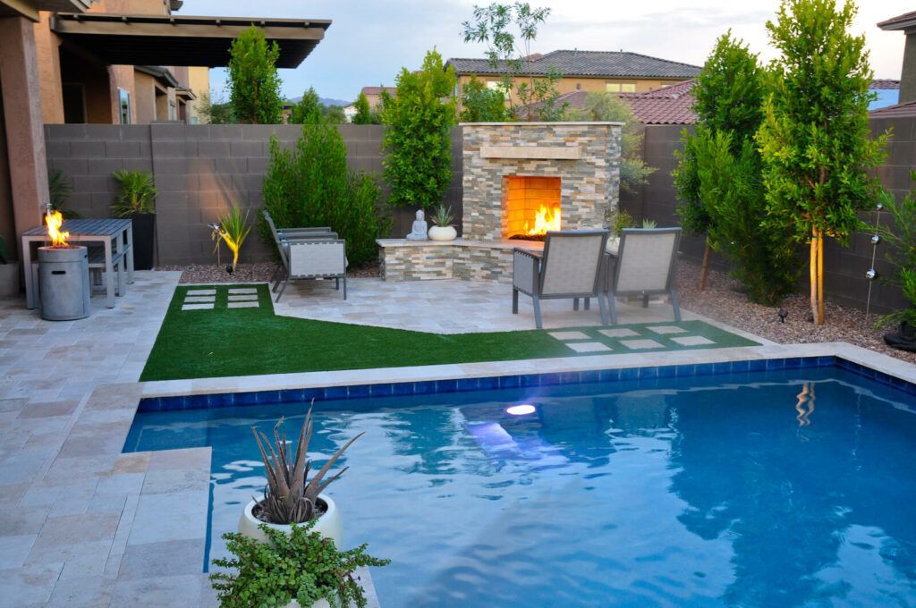 A swimming pool with a fireplace in the backyard