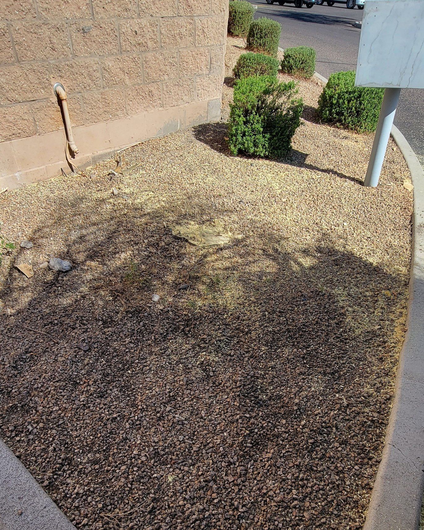 A pile of gravel is sitting in front of a building.