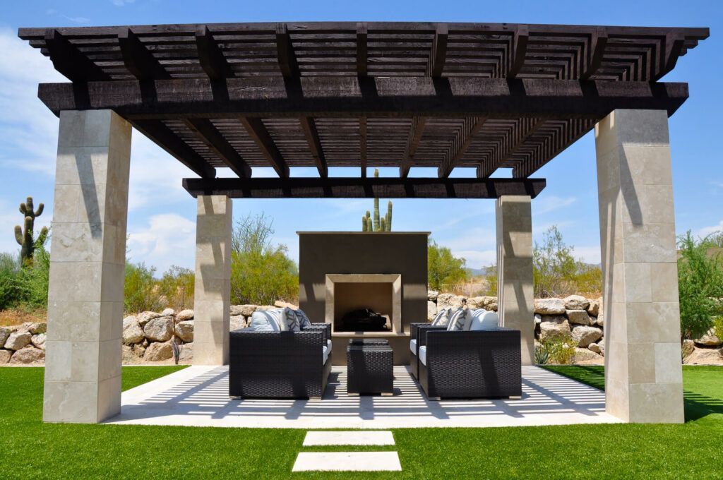 A patio area with a pergola and a fireplace