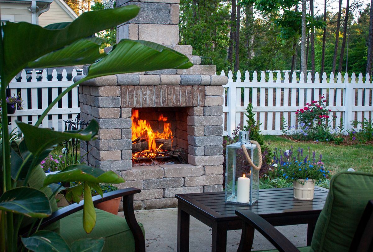 There is a fireplace in the backyard with a candle in it.