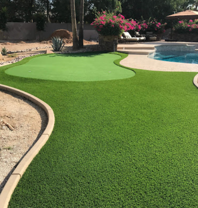 A backyard with a putting green and a pool