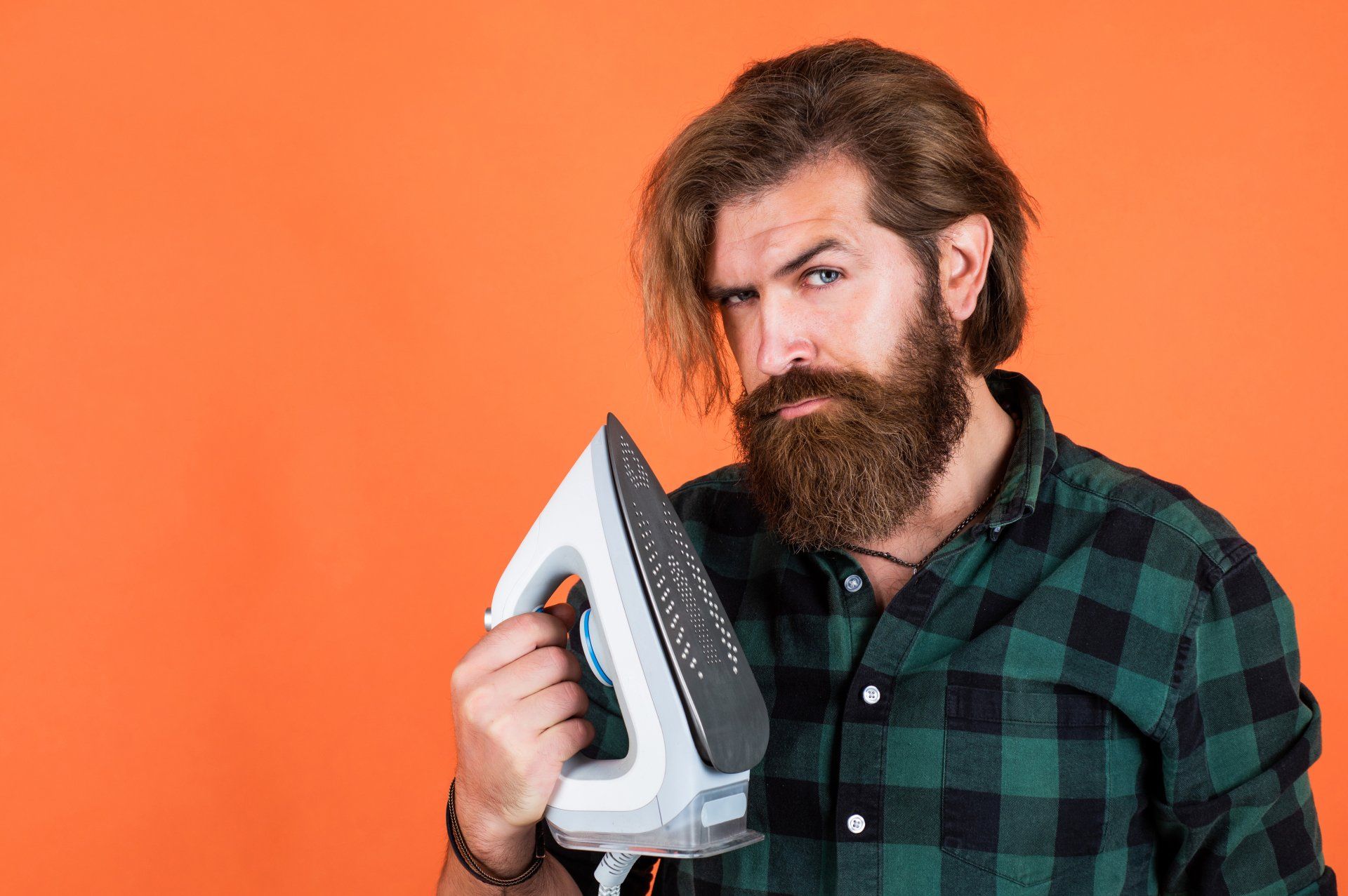 man holding an iron as a telephone
