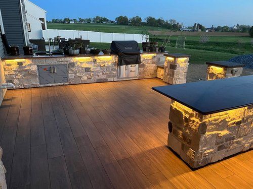 A large outdoor kitchen with a grill and a table.