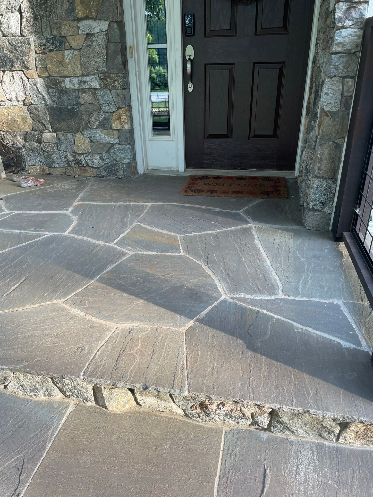 A stone walkway leading to the front door of a house.