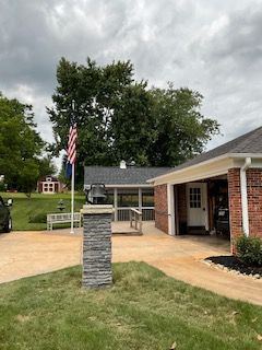 A house with a flag in front of it and a car parked in front of it.