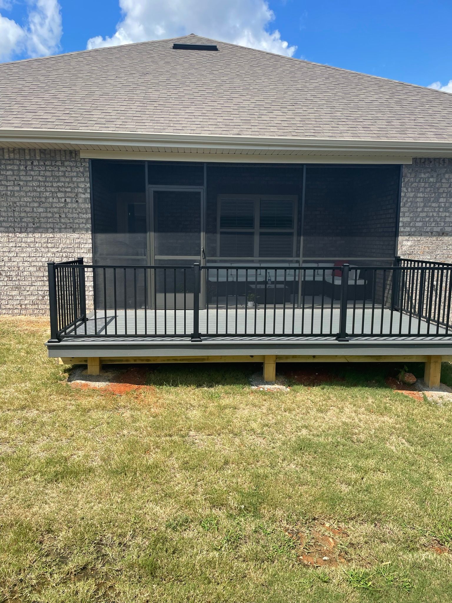 The back of a house with a screened in porch.