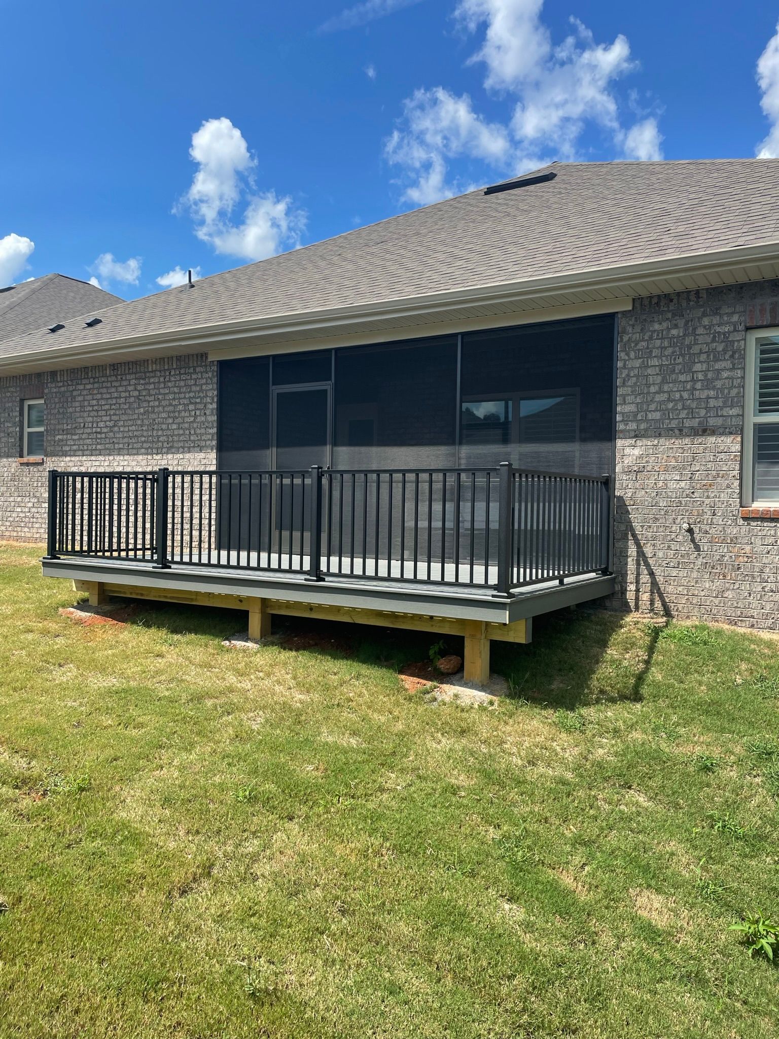 There is a screened in porch in the backyard of a house.