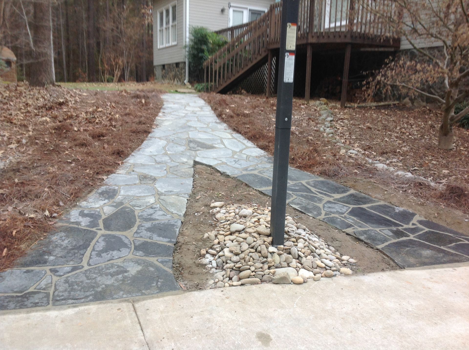 A stone walkway leading to a mailbox in front of a house