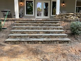 A stone staircase leading up to a porch of a house.