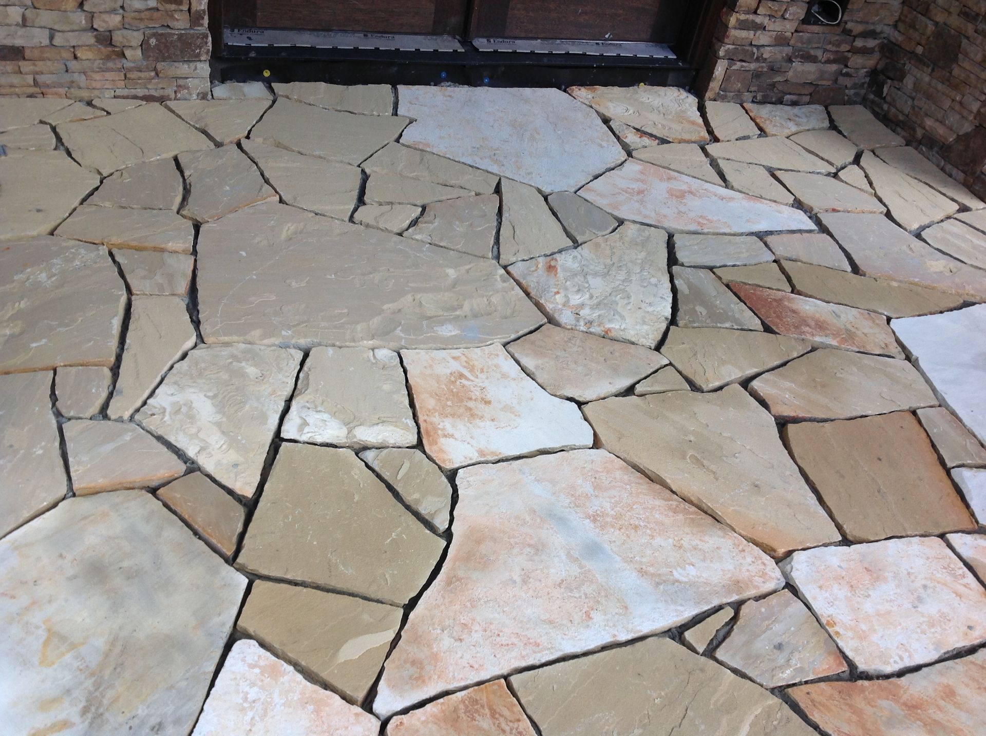 A stone walkway with a brick wall in the background