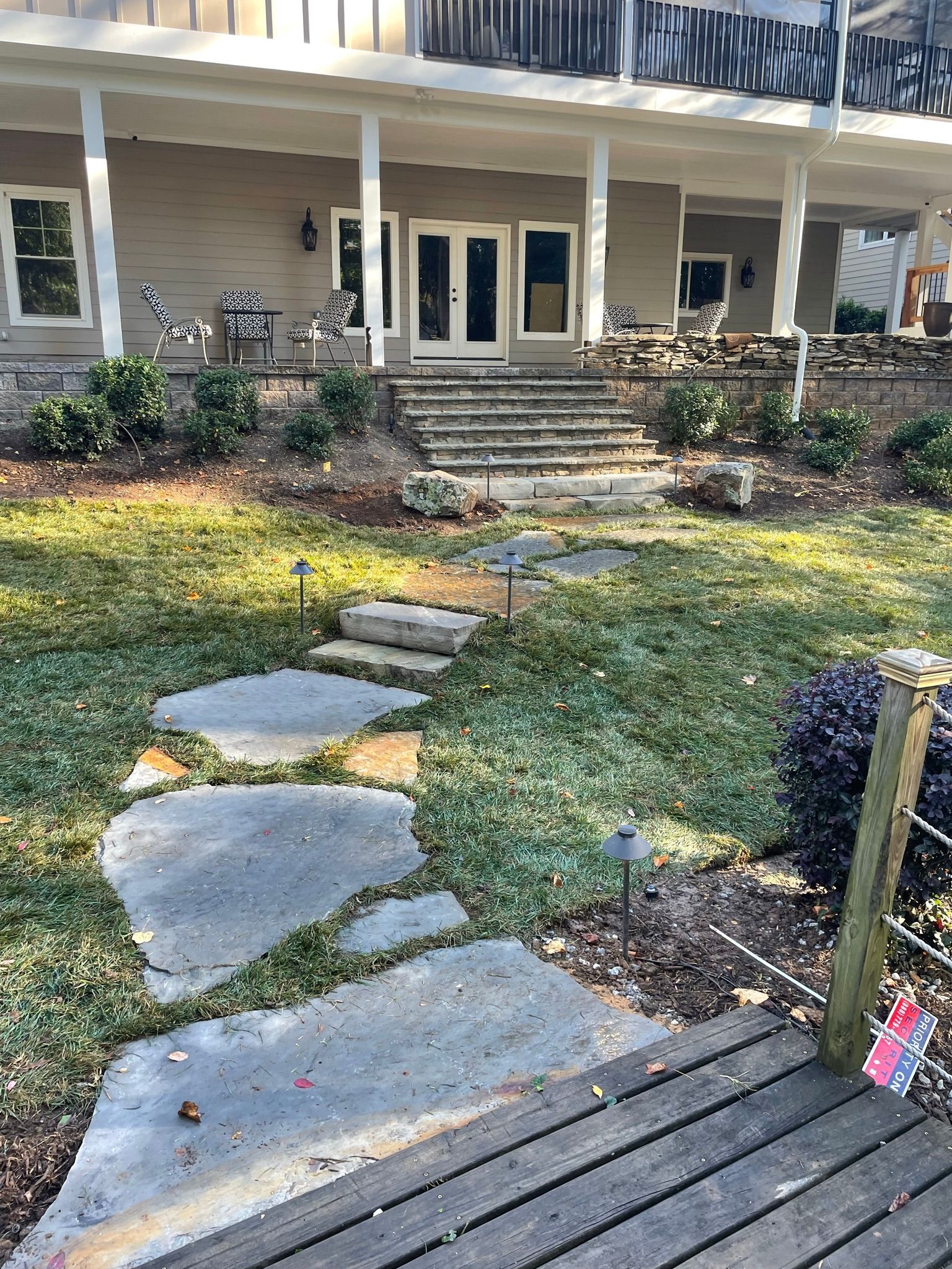 There is a walkway leading to the front of the house.