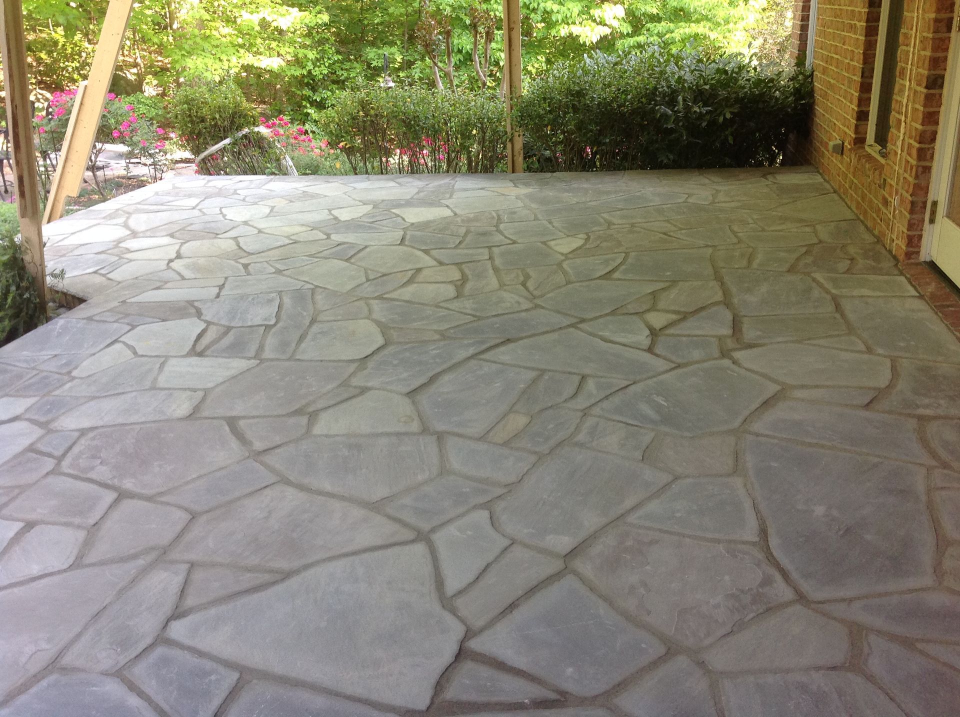 A large stone patio with a brick building in the background.