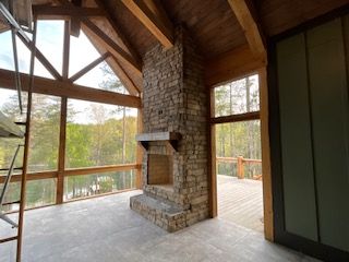 There is a stone fireplace in the middle of the room.