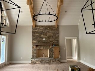 A living room with a fireplace and a chandelier hanging from the ceiling.