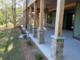 A large porch with wooden posts and stone pillars