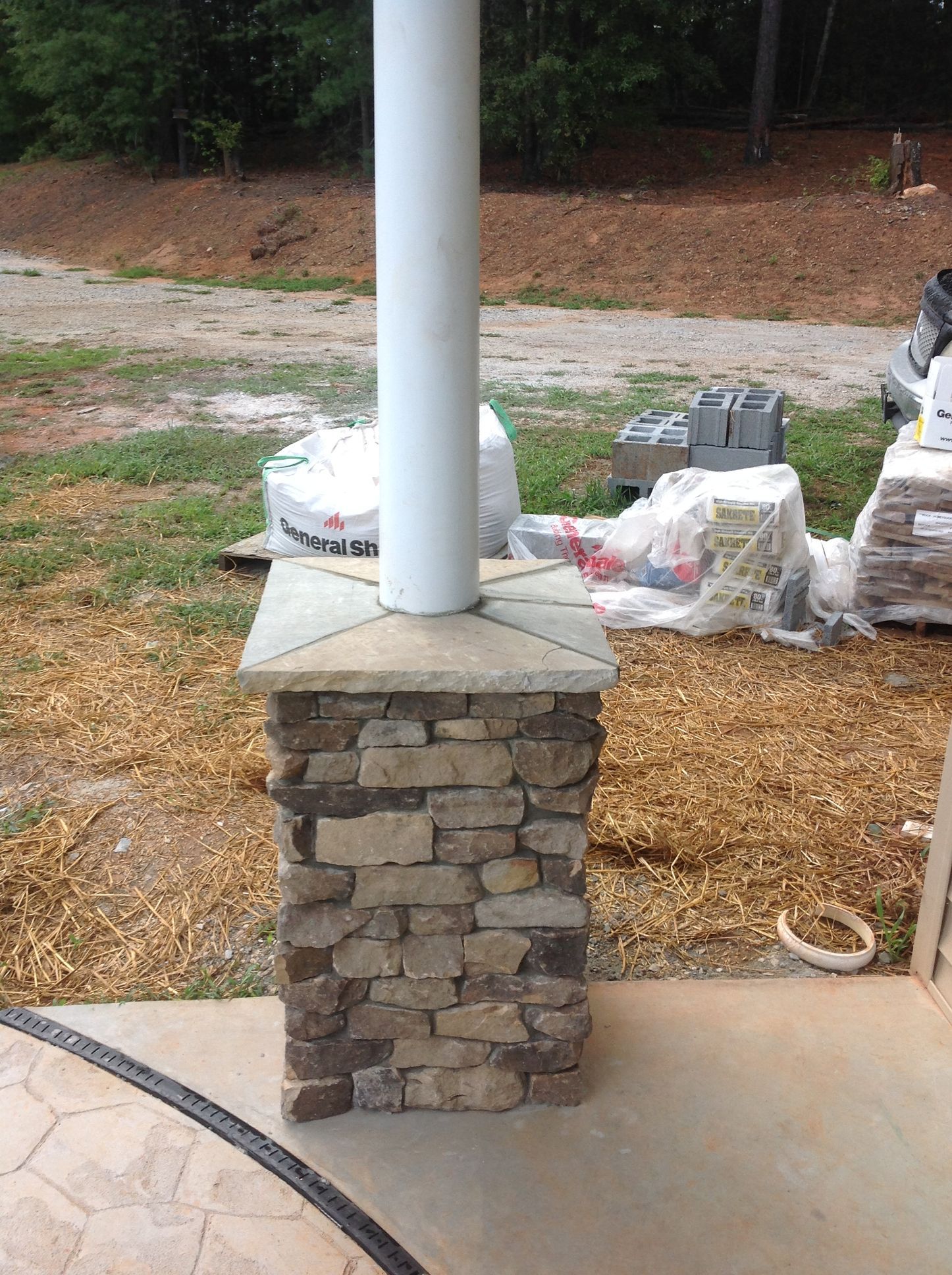 A white pole is sitting on top of a stone pillar.
