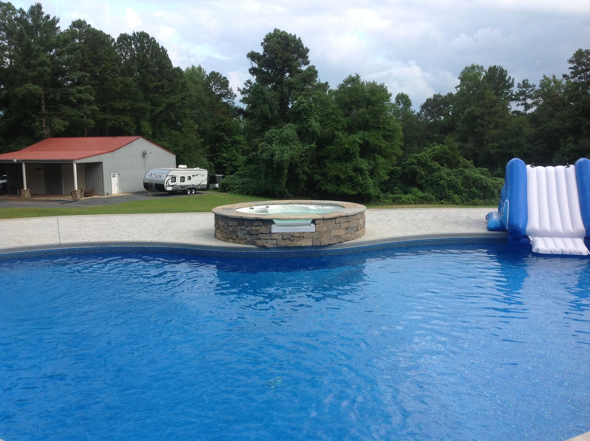 A large swimming pool with a hot tub in the middle
