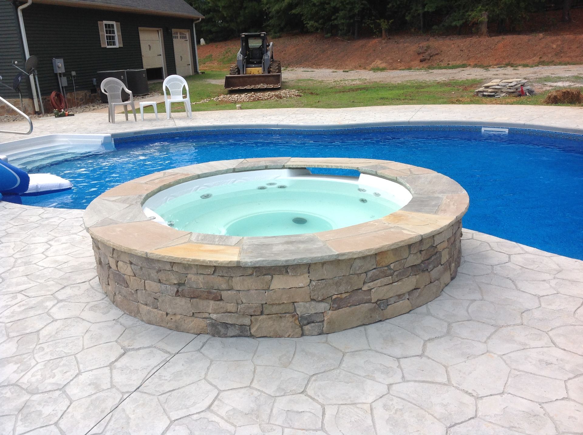 A hot tub is in the middle of a swimming pool.
