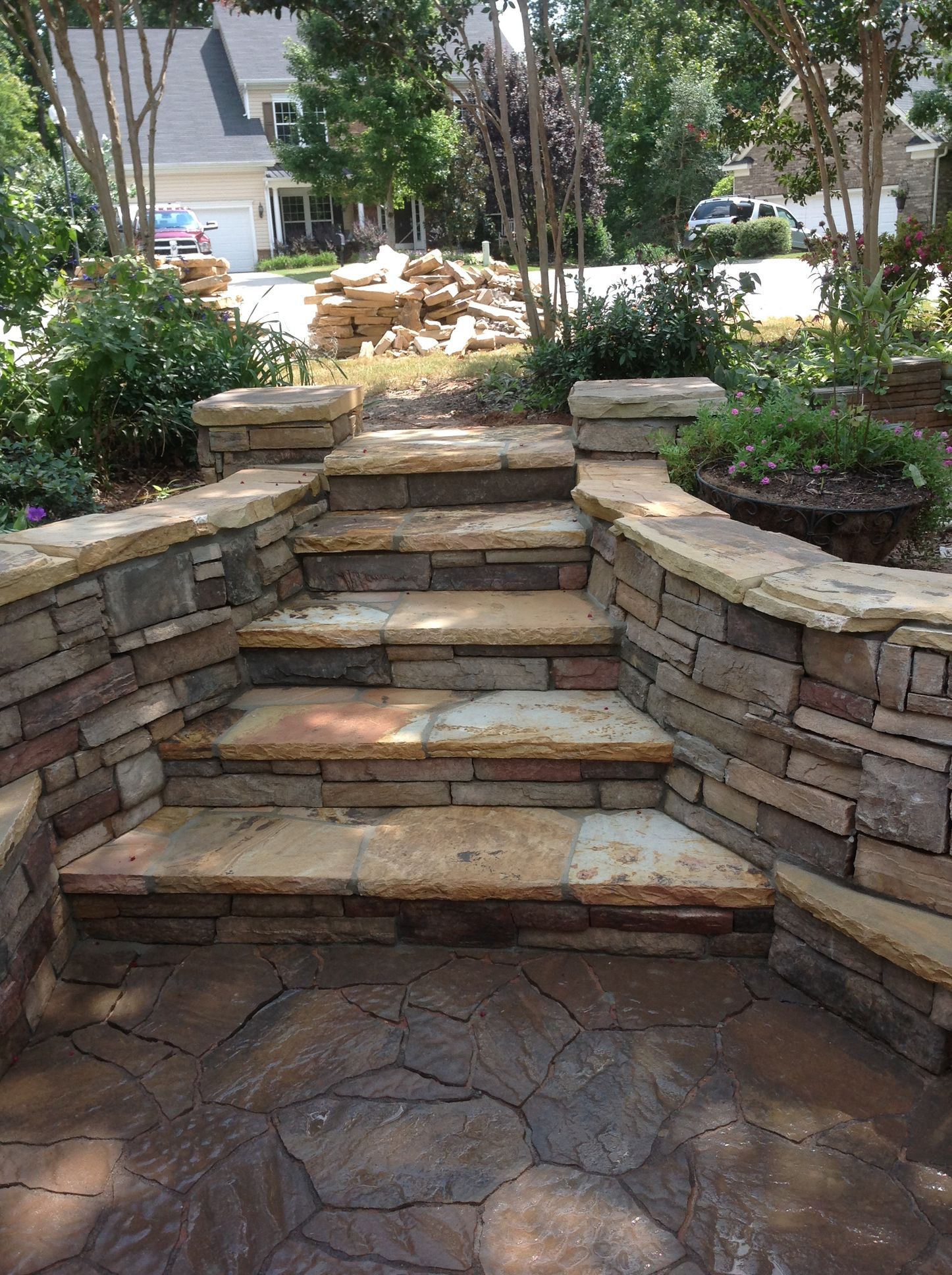 A stone wall with stairs leading up to a house