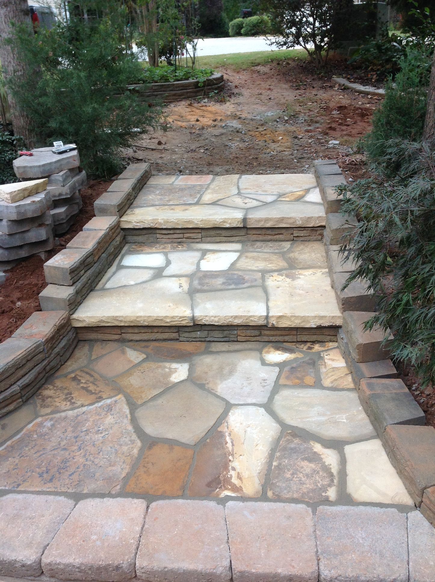 A stone walkway is being built in a backyard.
