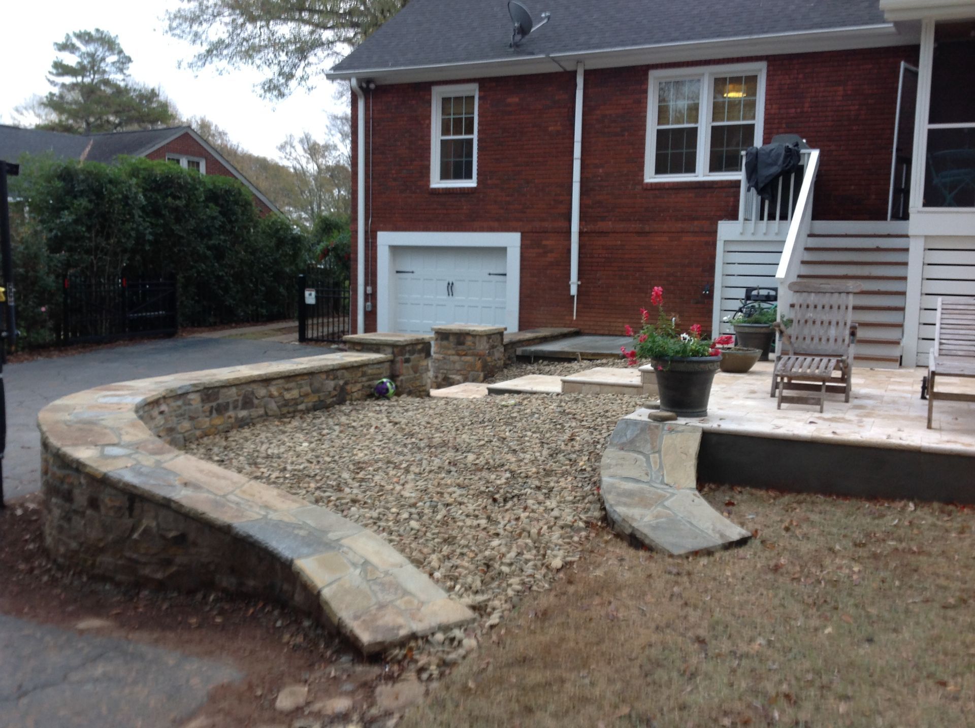 A brick house with a stone wall in front of it