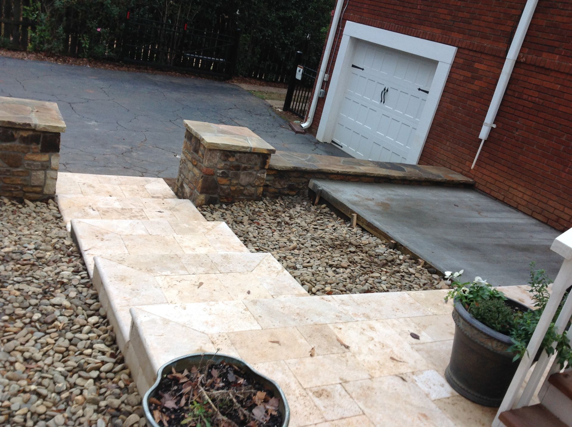 A brick house with a white garage door and stairs leading up to it