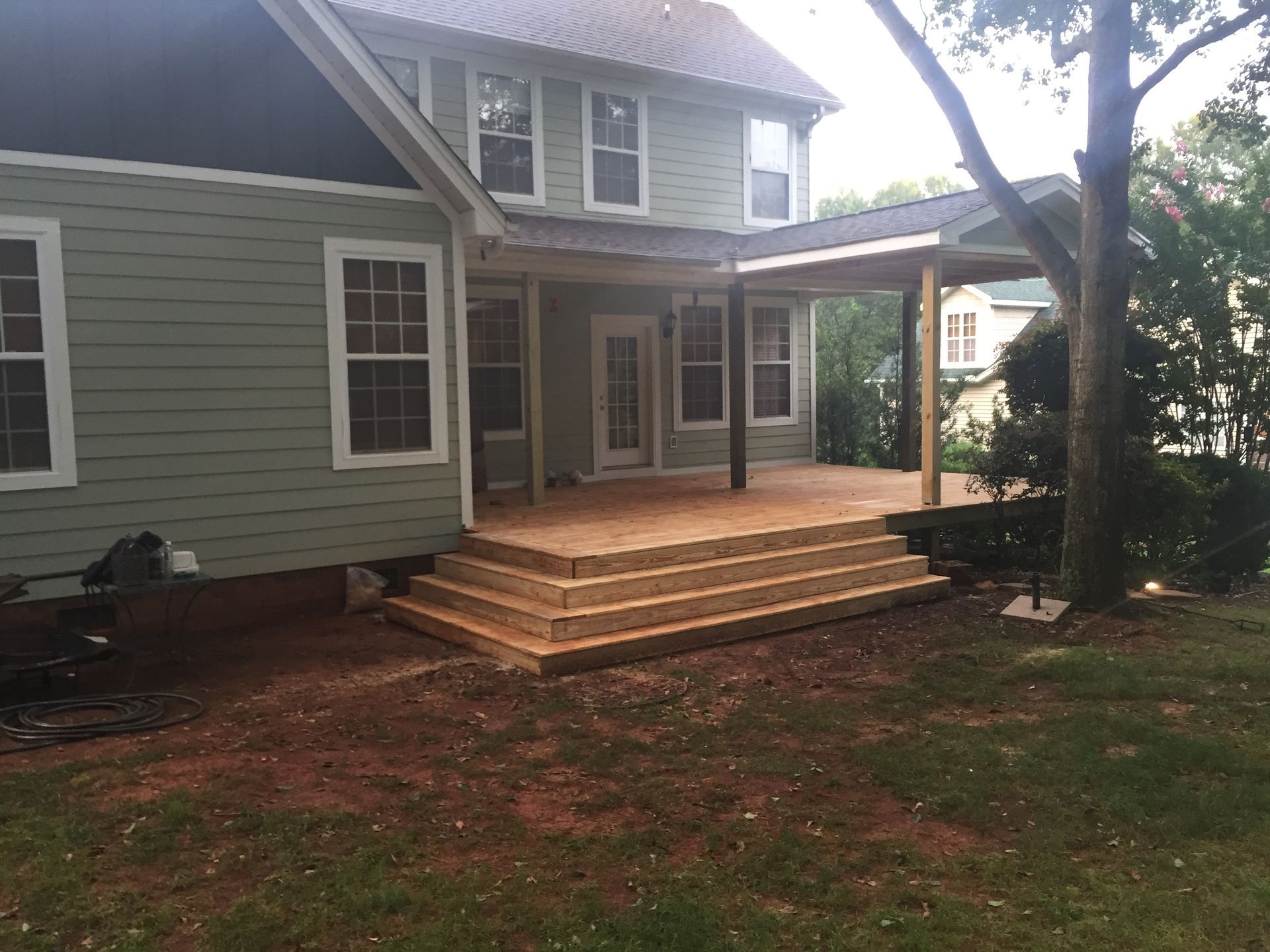A house with a large deck and stairs in front of it.