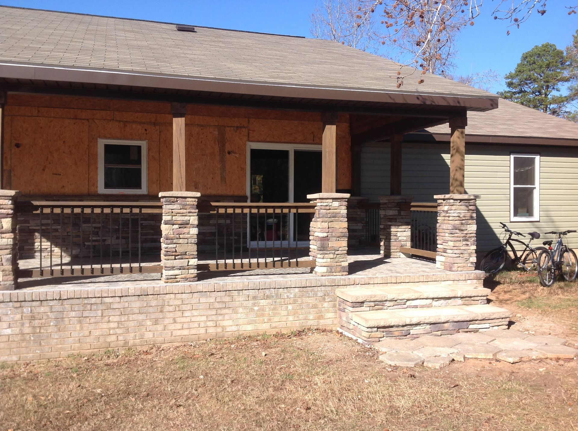 A house with a porch and a bicycle parked in front of it