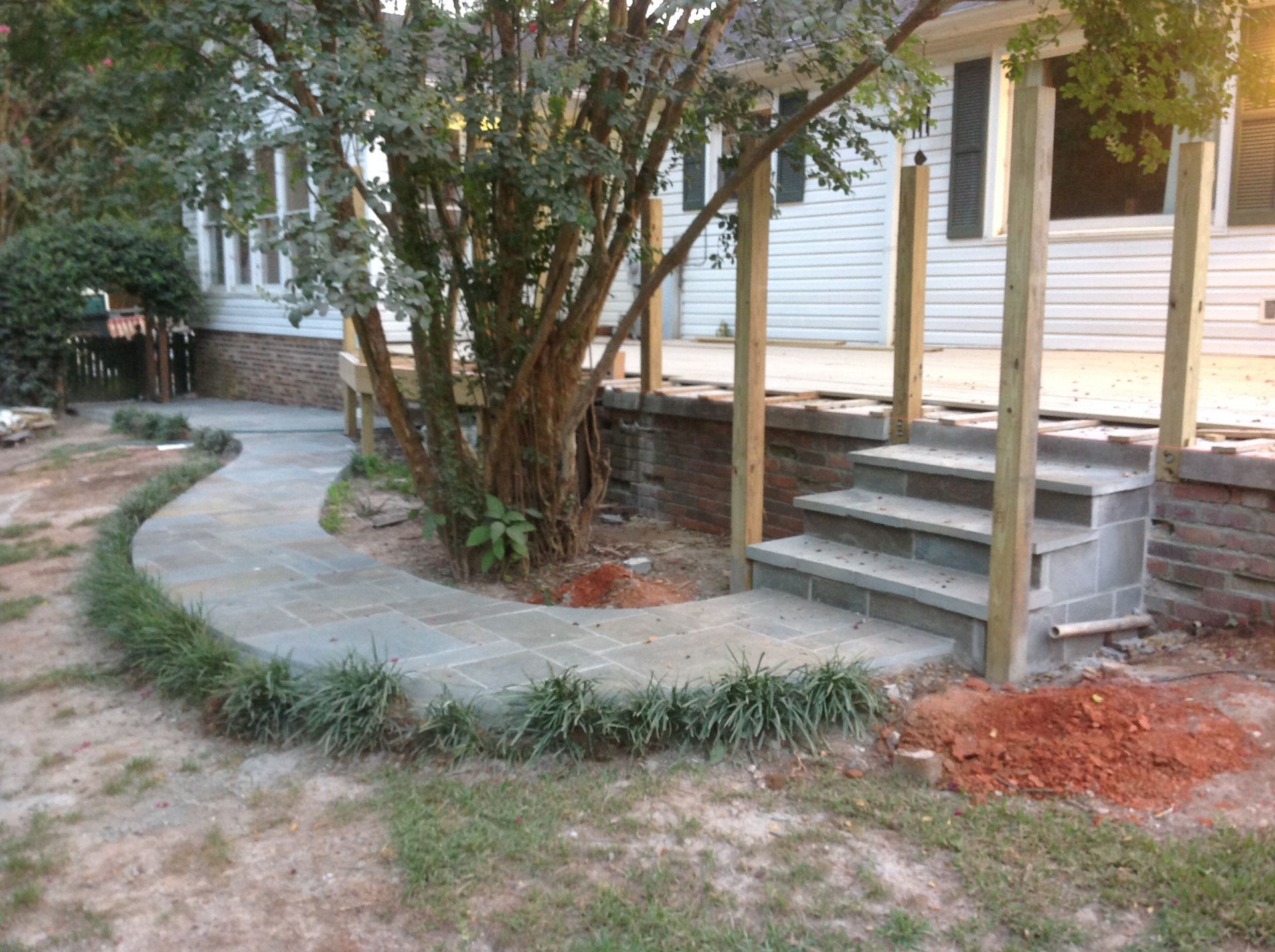 A concrete walkway leading to a house with stairs