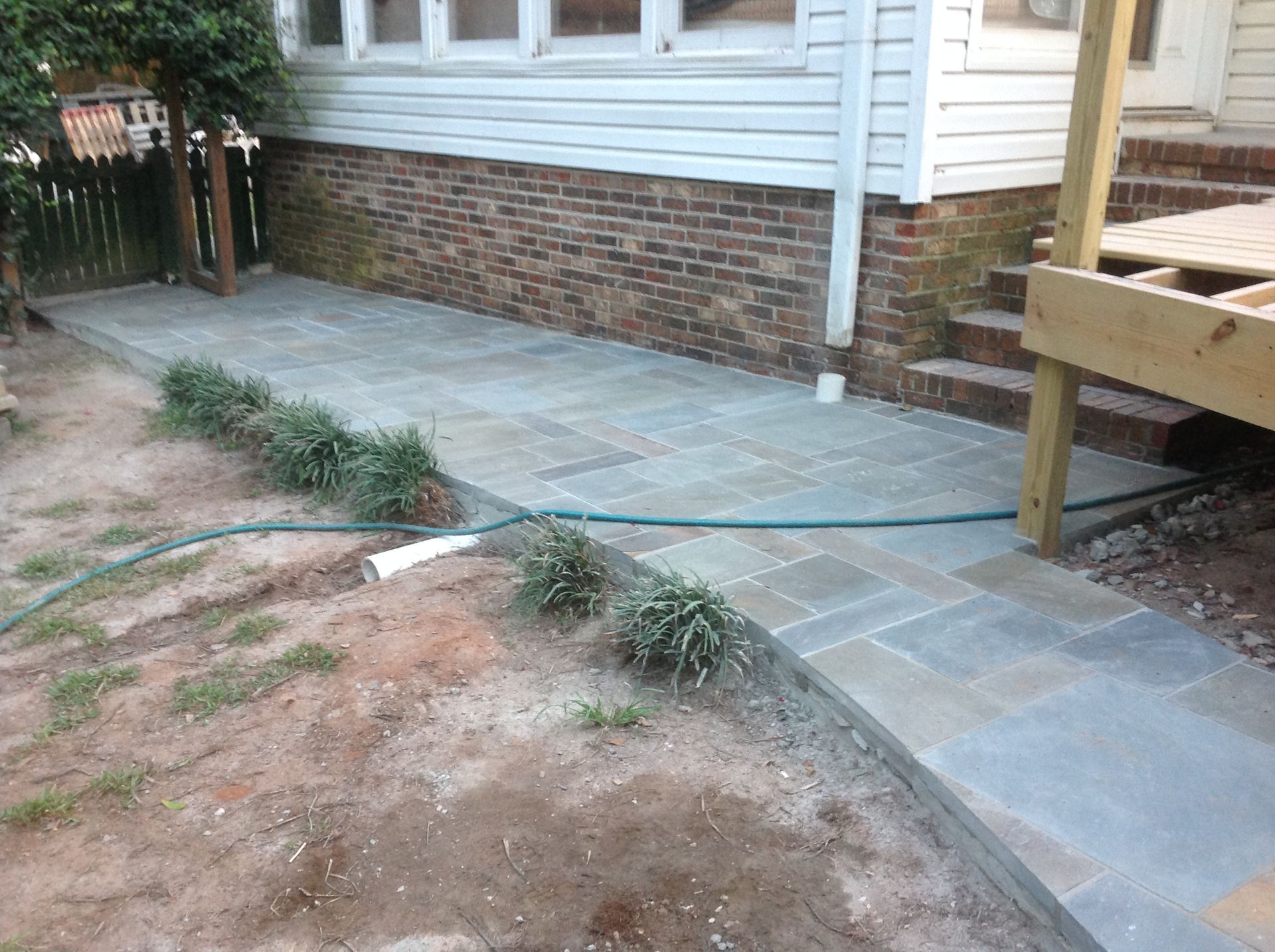 A hose is connected to a sidewalk in front of a house