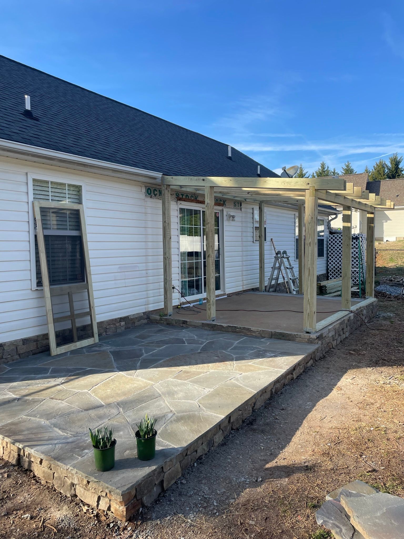 A house with a patio being built in front of it.