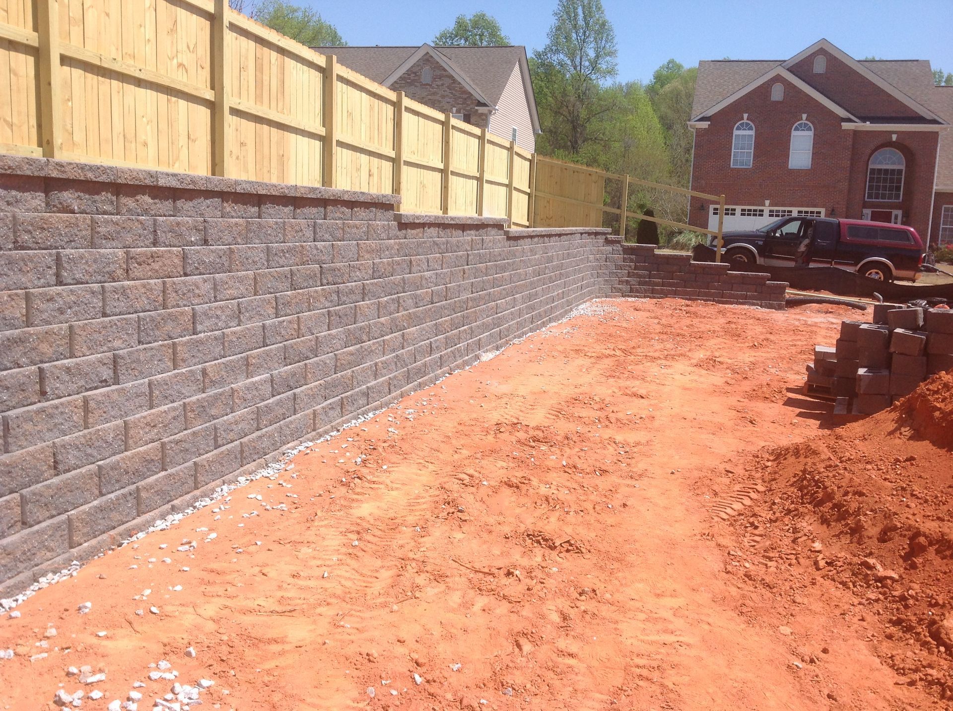 A brick wall is being built in front of a house