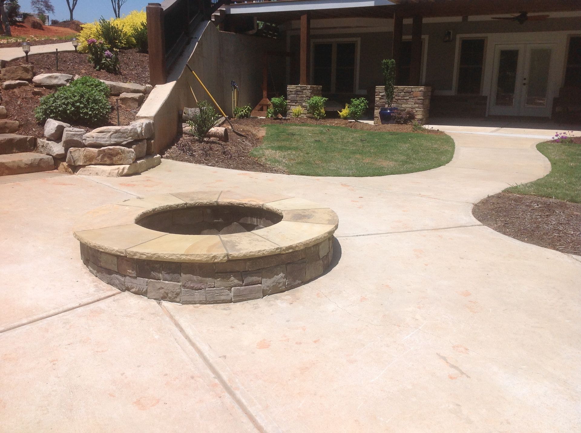 A concrete patio with a fire pit in the middle