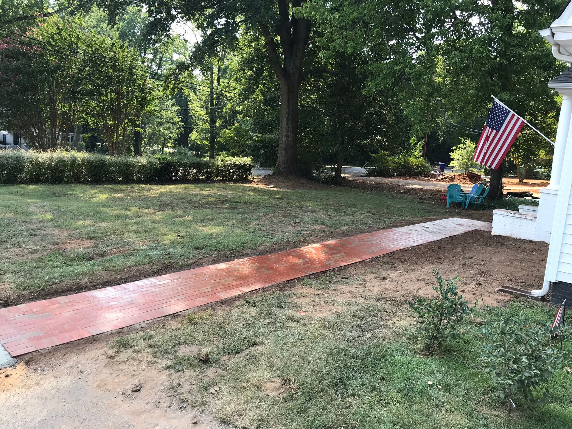 A walkway leading to a house with a flag on the side of it.