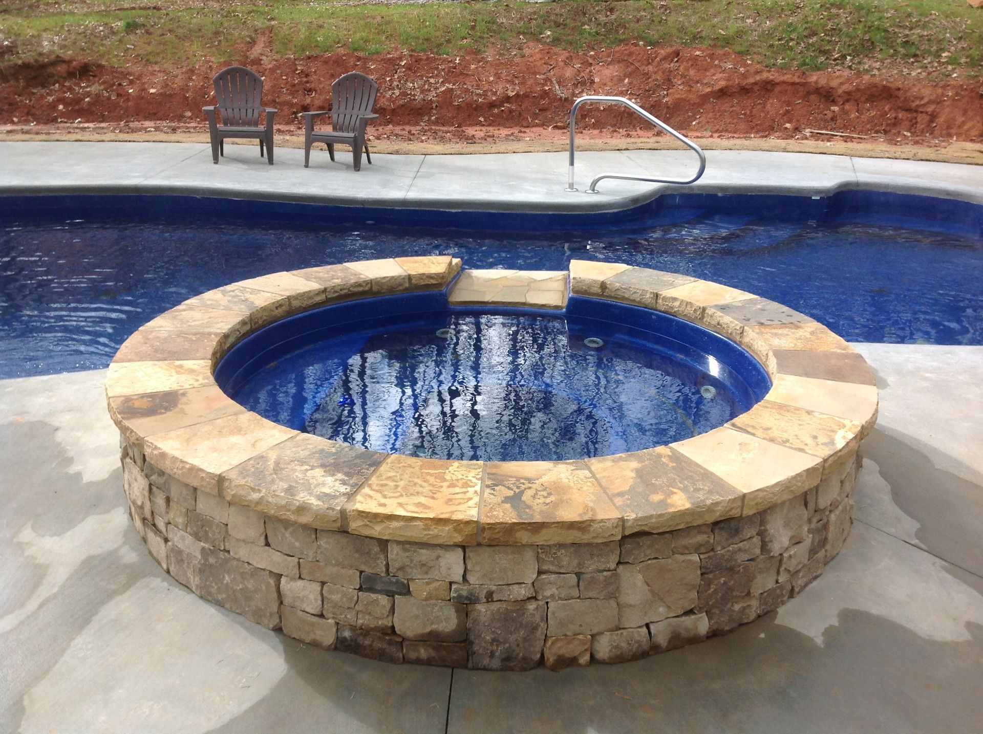 A pool with a hot tub in front of it