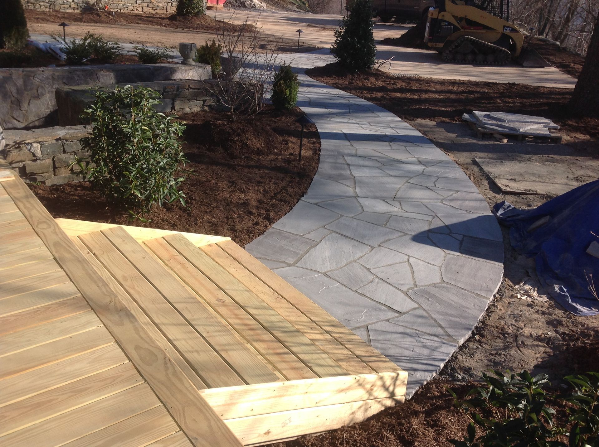 A walkway with a wooden deck in the background