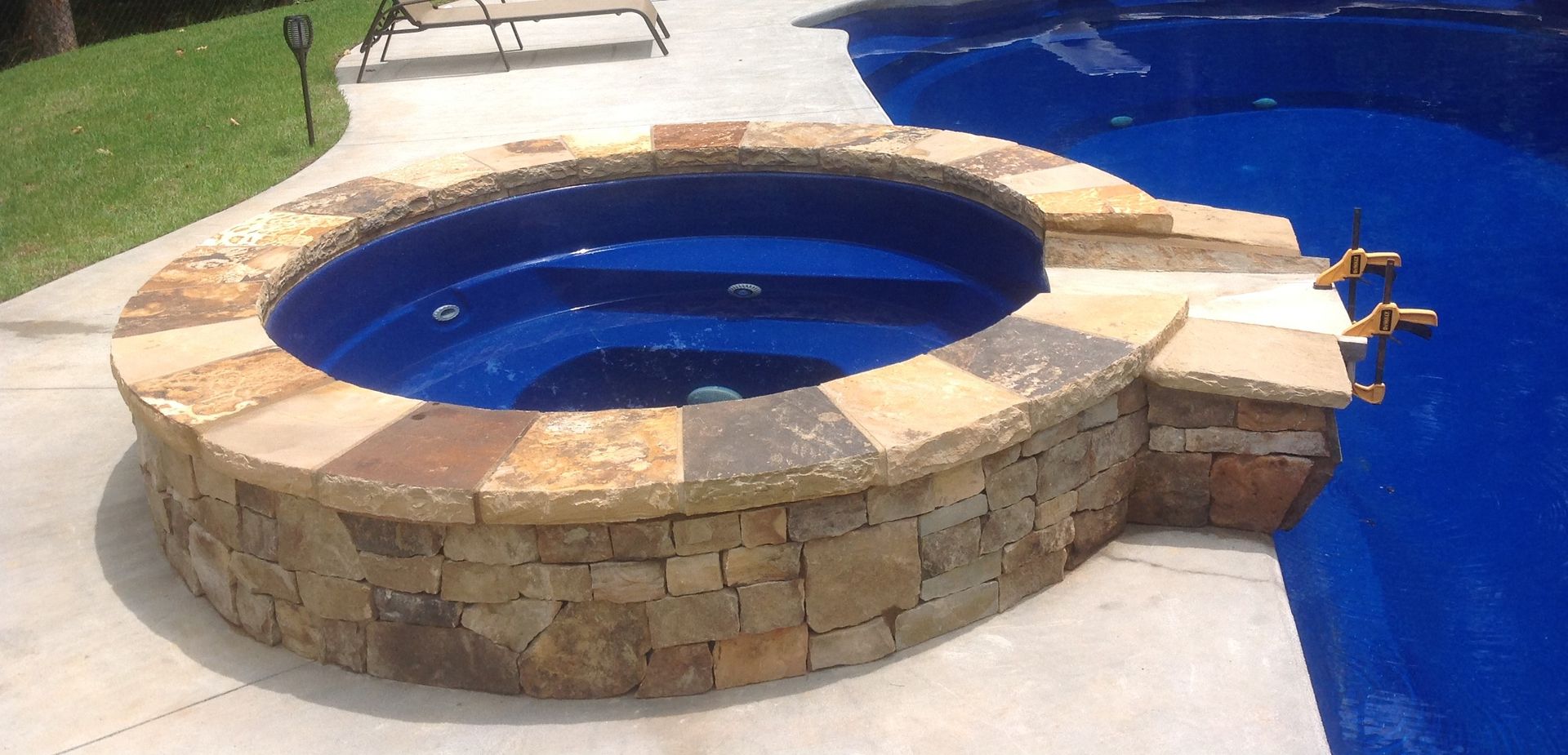 A hot tub is sitting next to a swimming pool