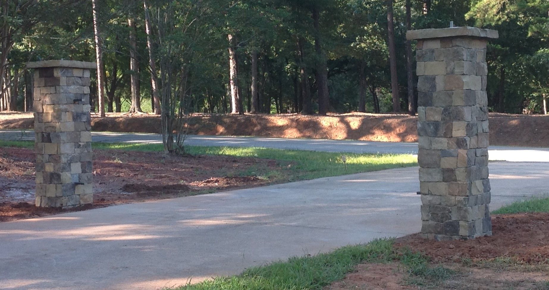 Two stone pillars in the middle of a driveway
