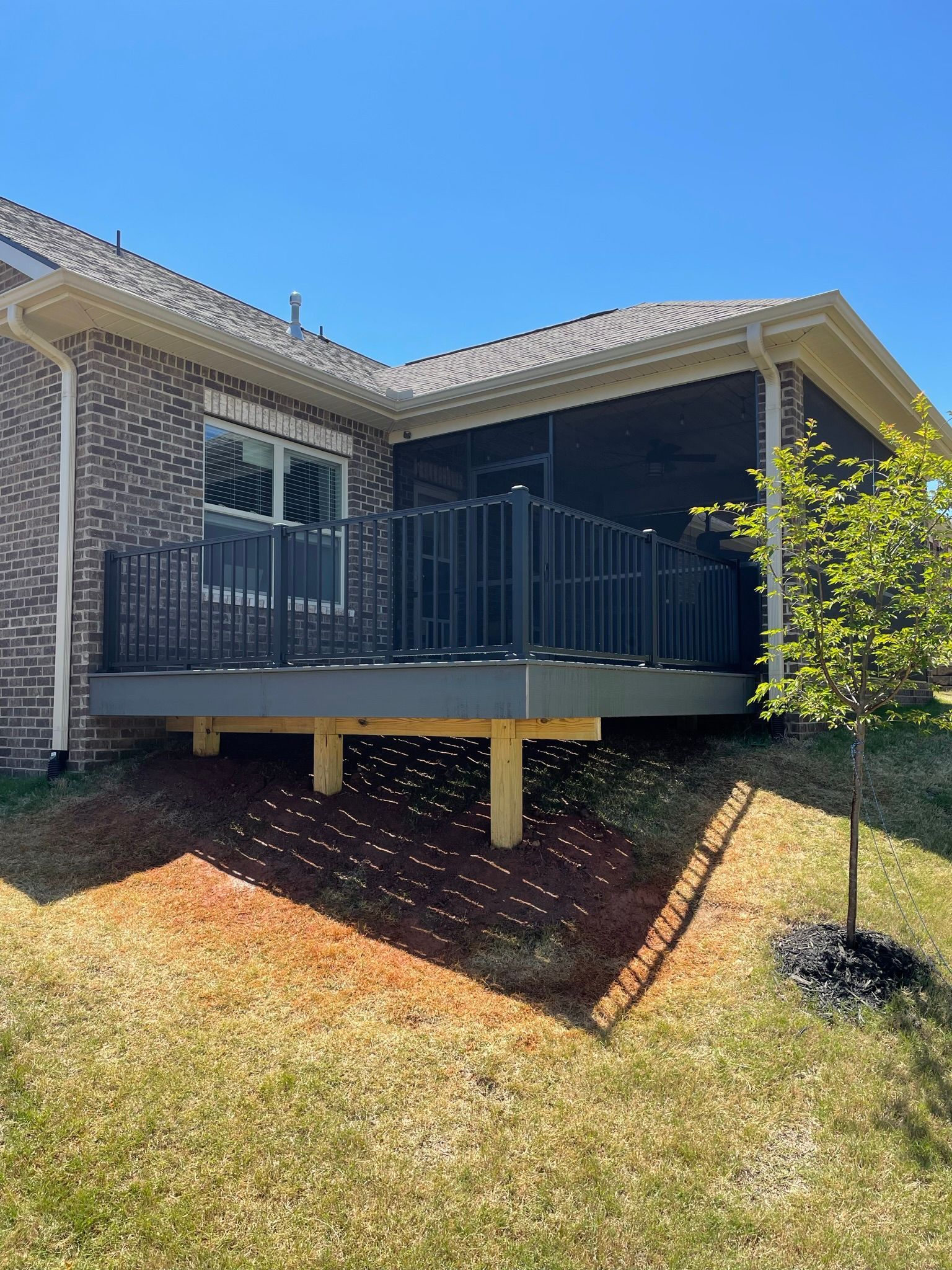 A house with a screened in porch and a deck.