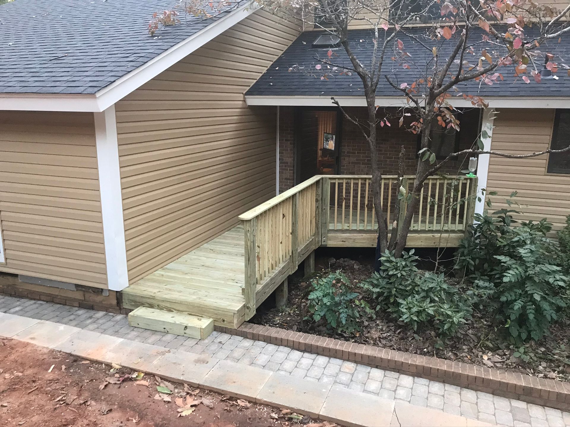 A house with a wooden deck and stairs leading to it.