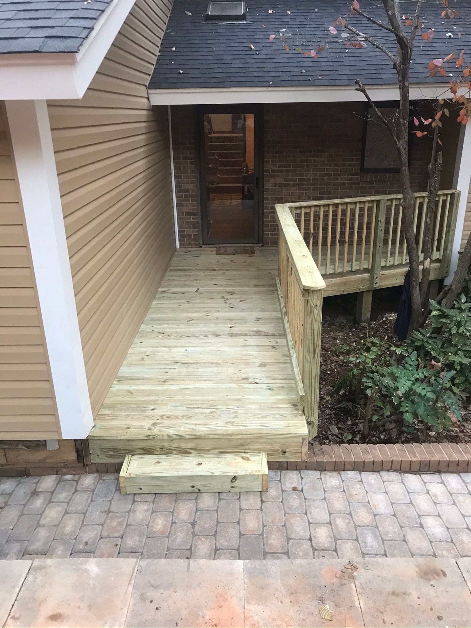 A wooden deck is being built in front of a house.