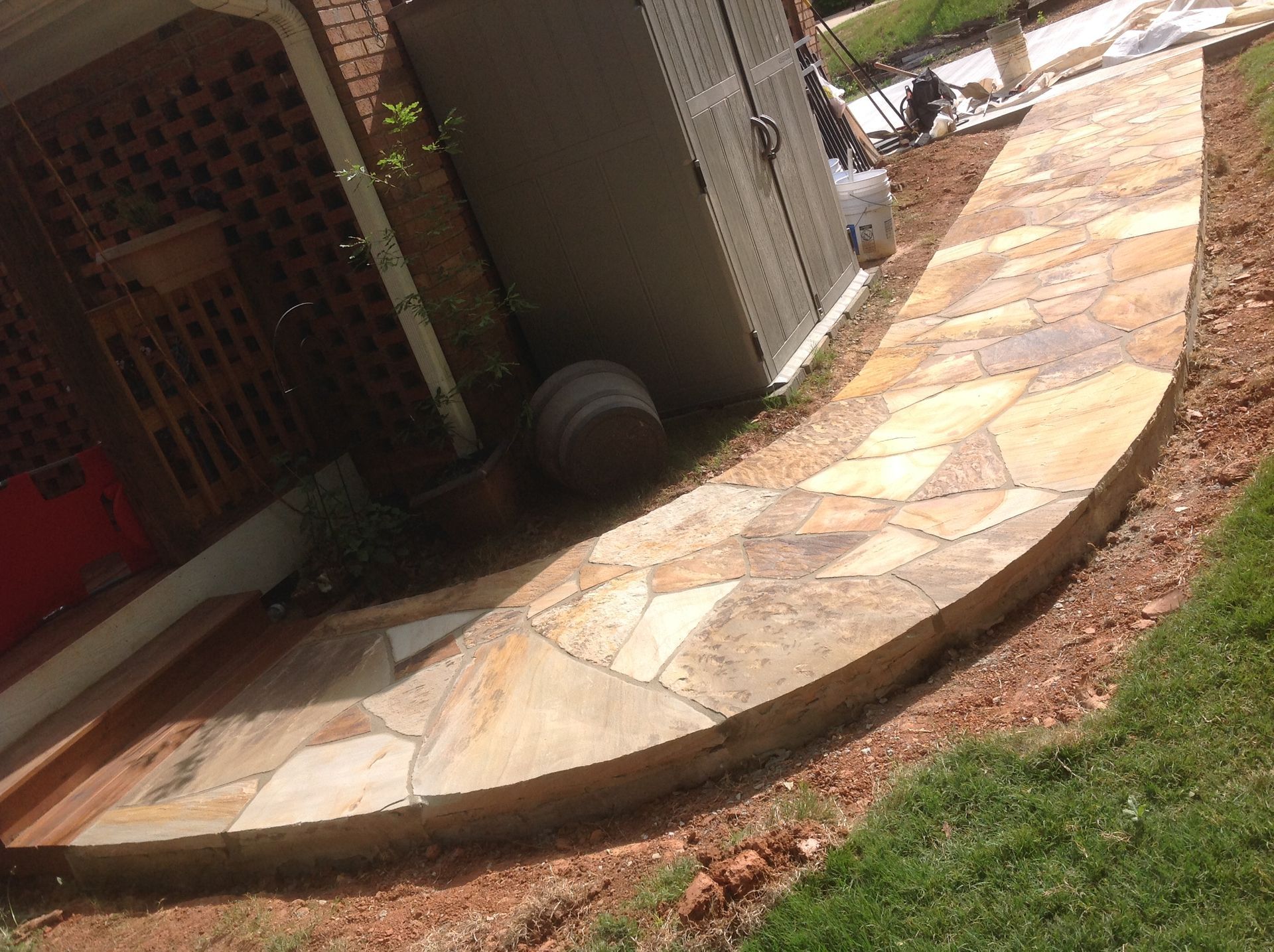 A stone walkway is being built in front of a house.